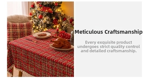 Close-up of Christmas plaid tablecloth featuring white pom-pom fringe and festive red green pattern