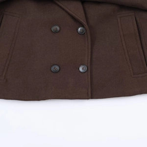 Detail of brown double-breasted wool coat showing dark buttons and pocket texture