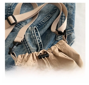 Close-up of khaki nylon drawstring bucket bag showing stitching and hardware details