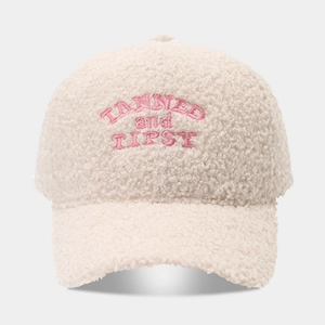 Detail of plush lamb wool baseball cap in beige with pink TANNED and TIPSY embroidery