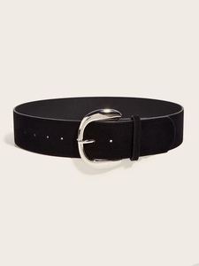 Close-up of black suede wide belt with polished silver horseshoe buckle on white background