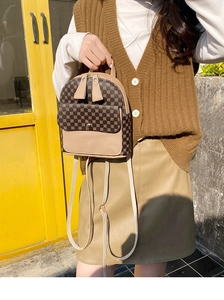 Detail of a mini printed backpack with brown leather accents and adjustable straps
