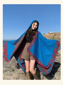 Outdoor detail of blue hooded poncho with red ethnic pattern trim for travel