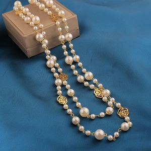 Elegant long pearl sweater necklace with hollow gold camellia rose accents and layered style