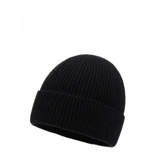 Detailed close-up view of black knitted beanie hat with embroidered mountain logo