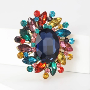Detail showing vintage brooch with large blue oval stone and colorful rhinestones