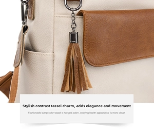 Detail of a chic cream and brown backpack featuring leather tassel and lychee texture