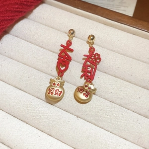 Detail of red and gold Chinese character earrings in white jewelry display box