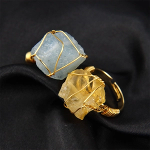 Detail of handmade gold wire-wrapped natural raw stone rings with adjustable band