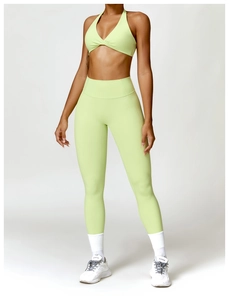 Detail of high-waist light green yoga leggings and halter twist sport bra set