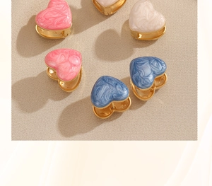 Flat lay of colorful heart earrings with pink white and blue marble enamel details