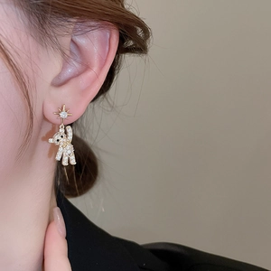 Detailed close-up of a golden teddy bear earring with sparkling micro-paved zircons on model