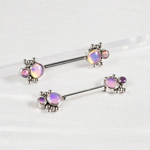Macro detail of stainless steel nipple rings with lavender opal and ball cluster studs
