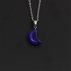 Gros plan d'un collier pendentif lune bleue avec chaîne argentée sur fond noir