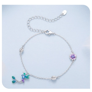 Detail of S925 sterling silver hummingbird bracelet with purple flower charm and crystals