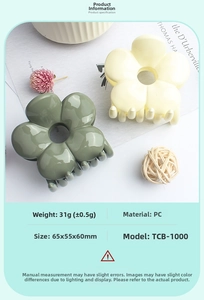 Detailed view of glossy flower-shaped hair claws in cream and dark green PC material