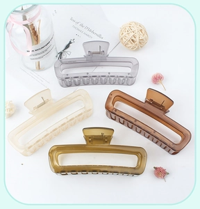 Flat lay of four square hollow hair claws in grey, beige, brown, and dark green colors