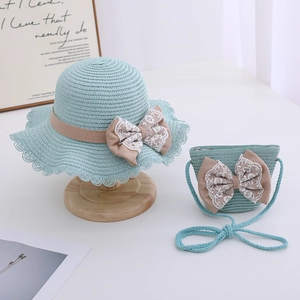 Detail of girls mint green straw hat and bag set with lace bows and wavy brim design