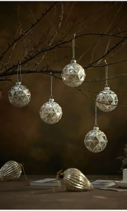 Macro detail of silver and gold geometric textured glass Christmas balls on tree branches