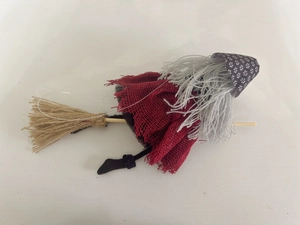 Detail of handmade Halloween witch doll with red burlap dress and grey yarn hair