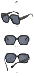 Makro-Detail der quadratischen schwarzen Sonnenbrille mit goldenem Herz-Akzent