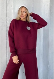 Detail of wine red sweatshirt set with heart print and wide-leg trousers on model
