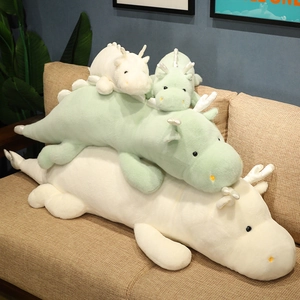 Soft cartoon dragon plush toy collection in white and green on a cozy sofa