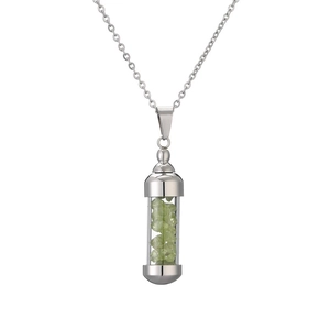 Détail d'un collier argenté avec pendentif flacon de parfum rempli de cristaux verts