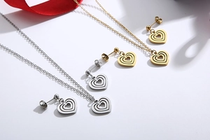 Detail view of heart-shaped necklace and earrings set in gold and silver finishes