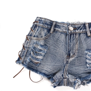 Detail von High-Waist-Jeans-Shorts mit Schnürung an der Seite und abgenutzten Metallösen