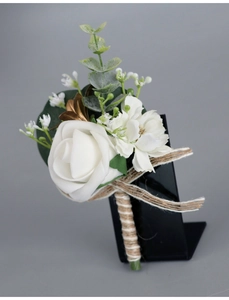 Detail of white PE rose boutonniere with eucalyptus, gold leaf, and jute rope handle