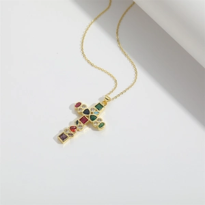 Detailed macro shot of golden cross pendant necklace with colorful inlaid gemstones