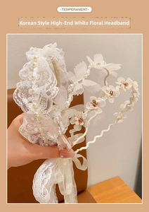 Macro shot of white lace headbands with pearls, mesh flowers, and crystal details