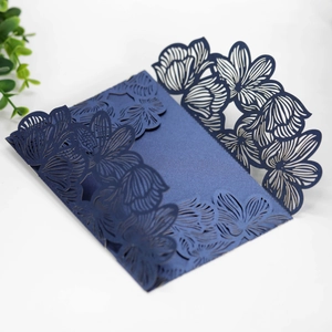 Close-up of navy blue laser-cut floral pattern on pearlescent paper invitation cover