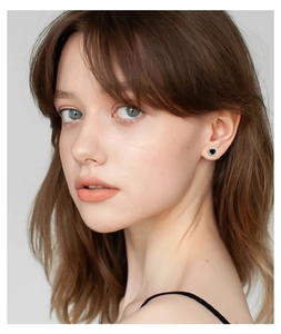 Close-up of elegant S925 silver stud earrings with black moissanite worn by a model