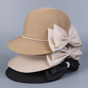 Détail de chapeaux de paille empilés avec nœuds élégants et décorations en perles