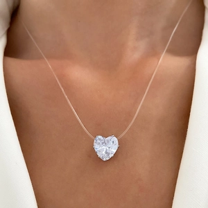 Transparent fishing line necklace with a heart-shaped zircon pendant on a female model