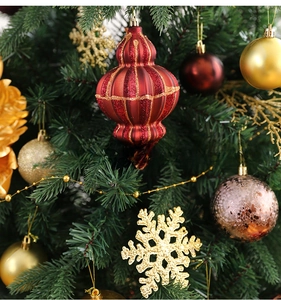 Detail von roten und goldenen Weihnachtskugeln mit gestreiften Anhängern und Flocken