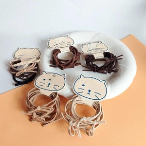 Close-up of high-elasticity hair ties with bows on cat-shaped cards in neutral tones