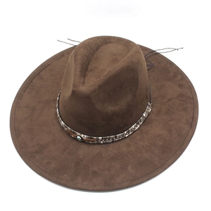 Detail of dark brown suede cowboy hat featuring ethnic woven band and evil eye charm