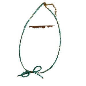 Handmade teal beaded necklace with a bow pendant and gold-plated lobster clasp closure