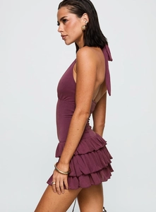 Detail shot of the tiered ruffle hem and open back on this purple halter mini dress
