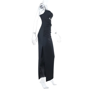 Détail d'une robe moulante noire avec fronces latérales et fente haute sexy sur l'ourlet