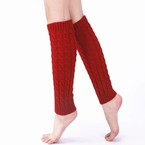 Close-up of wine red cable knit leg warmers showing thick braided texture and ribbed cuffs