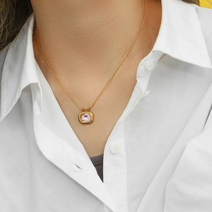 Close-up of 18K gold plated necklace with a square pink zircon stone pendant on a model