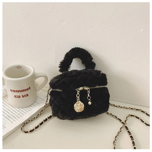 Close-up of black plush mini bag with gold chain strap and elegant golden rose pendant