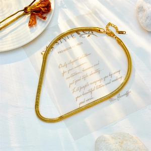 Elegant gold-tone Cuban snake chain necklace with lobster clasp on a white aesthetic background