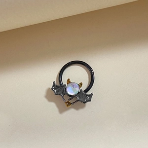 Black bat seamless nose ring with rainbow stone and gold accents on beige background