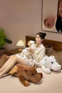 Close-up of soft white and brown plush pegasus dolls in a cozy bedroom setting