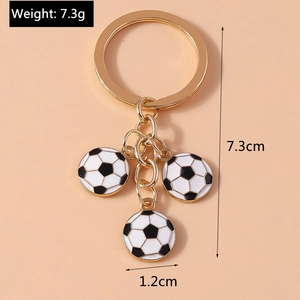 Detail view of gold keychain with three mini football charms showing size 7.3cm length
